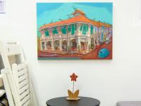 Singapore shophouse painting of Blair Road Corner displayed hung above a small table for size reference